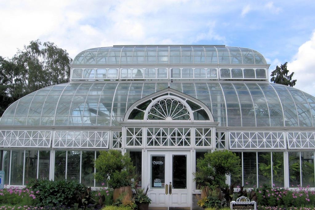 The Volunteer Park Conservatory is made of an intricate wood and iron framework, with 3,426 glass panes. Photo via Wikimedia Commons