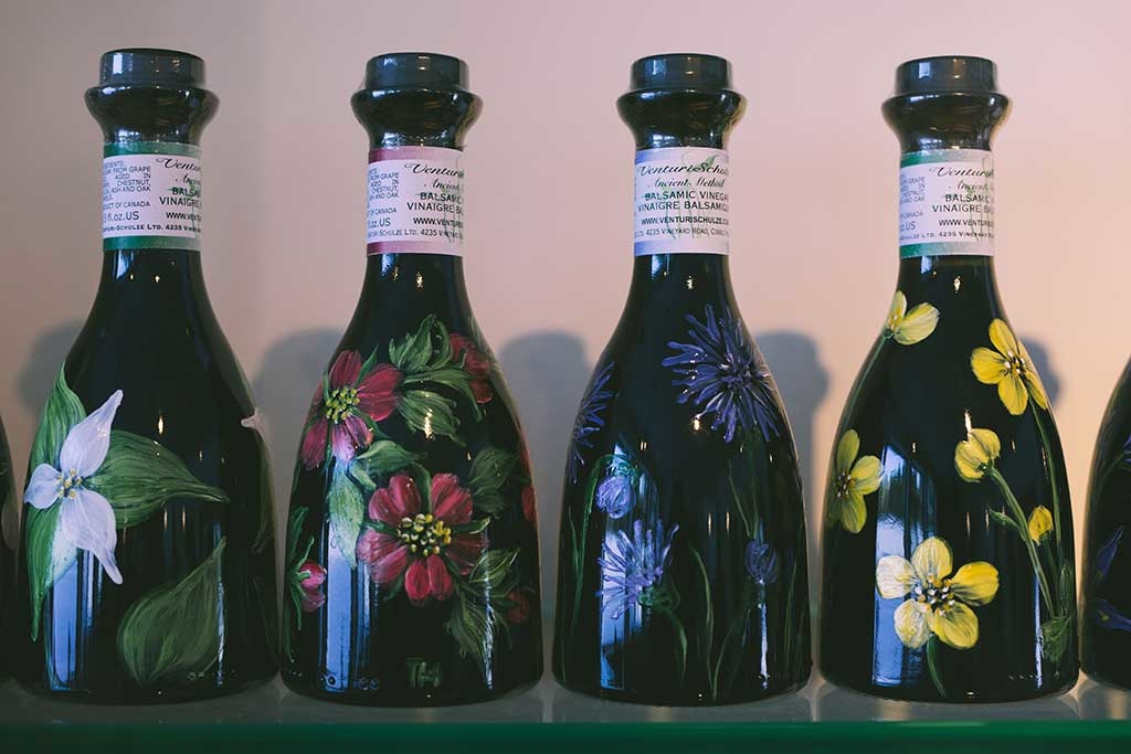 Hand-painted apple blossoms, blue camas, buttercups, dogwood and more adorn bottles of Classic balsamic. Photo: Nick Bentley