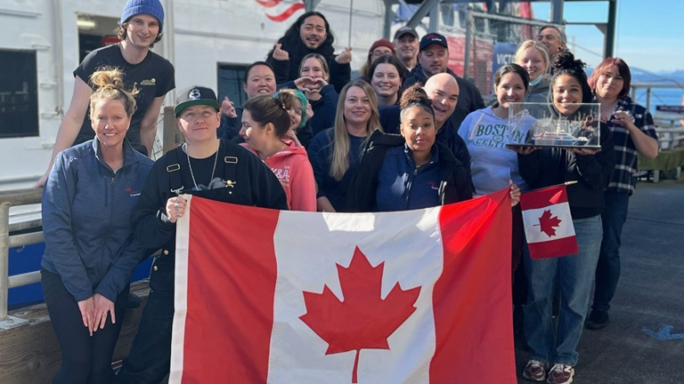 Clipper members in Victoria smiling and holding a Canadian Flag